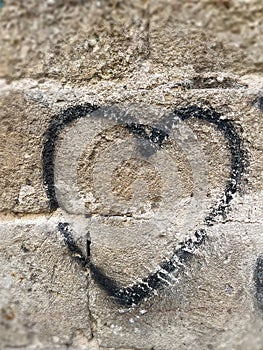 Black heart hand drawing on old garden wall