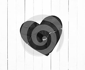 Black Heart representing Evil or Disease on White Wood Board Background with copy space.  A horizontal photo