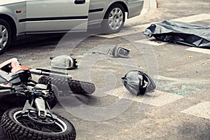 Black helmet and motorcycle on the road after fatal collision wi