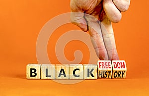 Black history and freedom symbol. Concept words Black history Black freedom on wooden cubes. Businessman hand. Beautiful orange