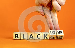 Black history and love symbol. Concept words Black history Black love on wooden cubes. Businessman hand. Beautiful orange table