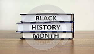 Black history month symbol. Books with words `Black history month`. Beautiful wooden table, white background. Black history mont