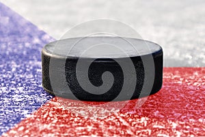 Black hockey puck on ice rink