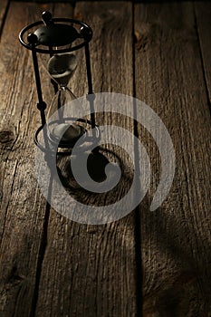 Black hourglass on a grey wooden background