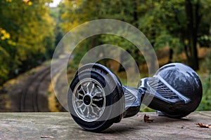 Black hoverboard against the background of railroad rails