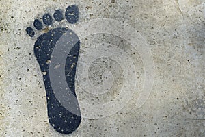 Black human footprint on cement floor