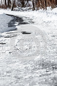 Black ice and snow on the country road or street, danger and accident risk at the winter season