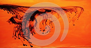 Black ink dispersing in orange water photo