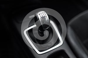 Black interior of a modern car, six-speed manual shift car gear lever.