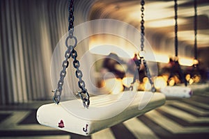 Black iron chain, hanging white swings Inside the empty room.shallow focus effect