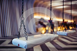 Black iron chain, hanging white swings Inside the empty room.shallow focus effect