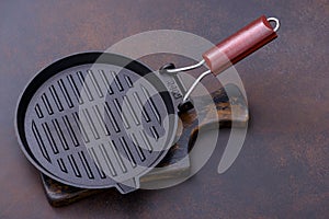 Black iron empty grill pan on cutting board