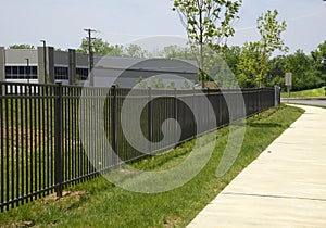Black iron fence by a sidewalk
