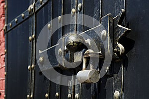 Black iron gate, brass squares and a lock with latch