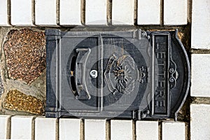 Black iron mailbox on a brick wall