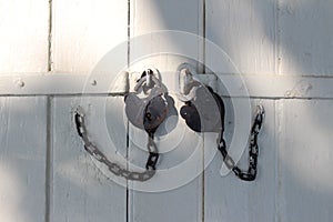 Black iron padlocks on the vintage wooden gate