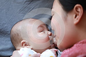 Black isolated background baby and mother mom face-to-face look at each other smile on face happy family maternal love