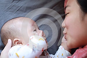 Black isolated background baby and mother mom face-to-face look at each other smile grin on face happy family maternal love