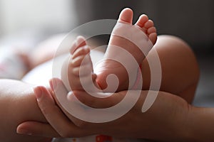 Black isolated background mother mom hold son new-born baby feet on palm hand maternal love family happiness concept