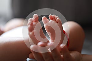 Black isolated background mother mom hold son new-born baby feet on palm hand maternal love family happiness concept