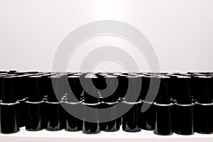 black jars of varnishes stand in order in rows