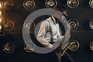 Black jazzman in hat plays the saxophone on stage