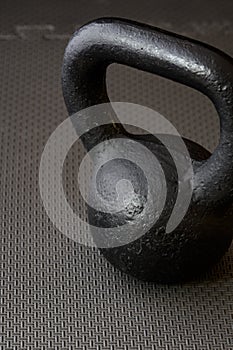 Black kettlebell on a black gym floor
