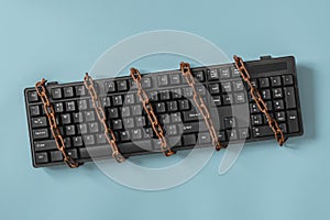 Black keyboard with a coiled chain. Concept for the topic of censorship or freedom of the press