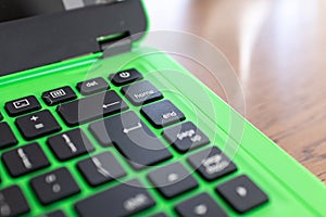 black keyboard on a green laptop. keys with letters and numbers. Detail of a laptop computer. Image detail to describe IT tools,