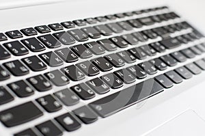 Black keyboard in white laptop close-up with perspective