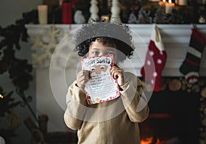 Black kid with Christmas wishlist paper