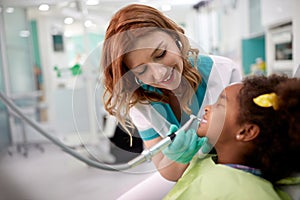 Black kid with female dentist in dental clinic photo
