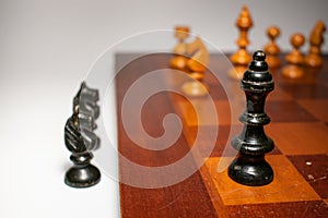 The black king of chess, standing in front of the whole squad of the white pieces