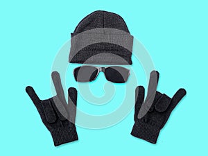 Black knitted hat beanie and gloves on a blue background