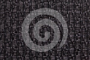 Black knitted woolen background with a pattern of soft, fleecy cloth. Texture of textile closeup.