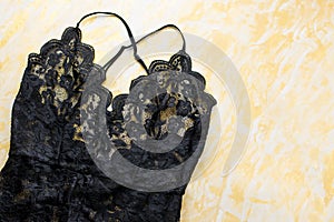 Black lace lingerie with beauty care products, make up cosmetics, jewelry in black and gold. Fashion flat lay, top view