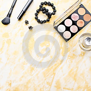 Black lace lingerie with beauty care products, make up cosmetics, jewelry in black and gold. Fashion flat lay, top view