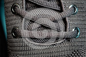 Black laces on sneakers, holes for laces close-up.