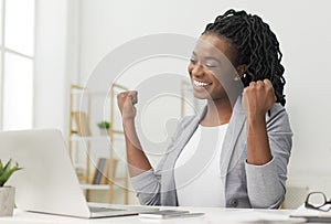 Black Lady Celebrating Business Success Sitting At Laptop In Office