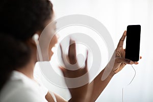 Black lady waving at smartphone with empty screen