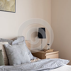 Black lamp on wooden bedside table, close-up