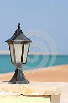 Black lantern along seashore