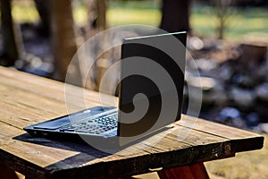 Black Laptop Angled on Picnic Table Outdoors