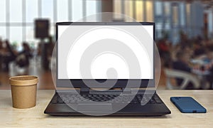 Black laptop with blank screen stands on table with blurred background