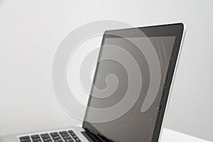Black laptop with broken screen isolated on white background