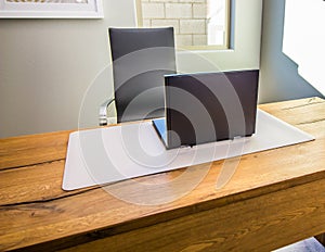 Black Laptop Computer On Desk Mat On Empty Desk