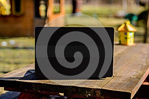 Black Laptop on Picnic Table Outdoors