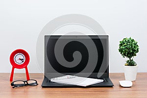 Black laptop on wooden table