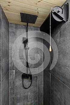 Black large square shower head, rain watering can in the bathroom