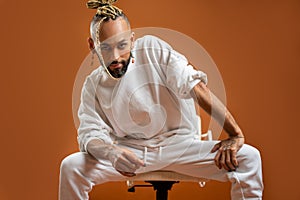 Black latin gay man isolated on orange background